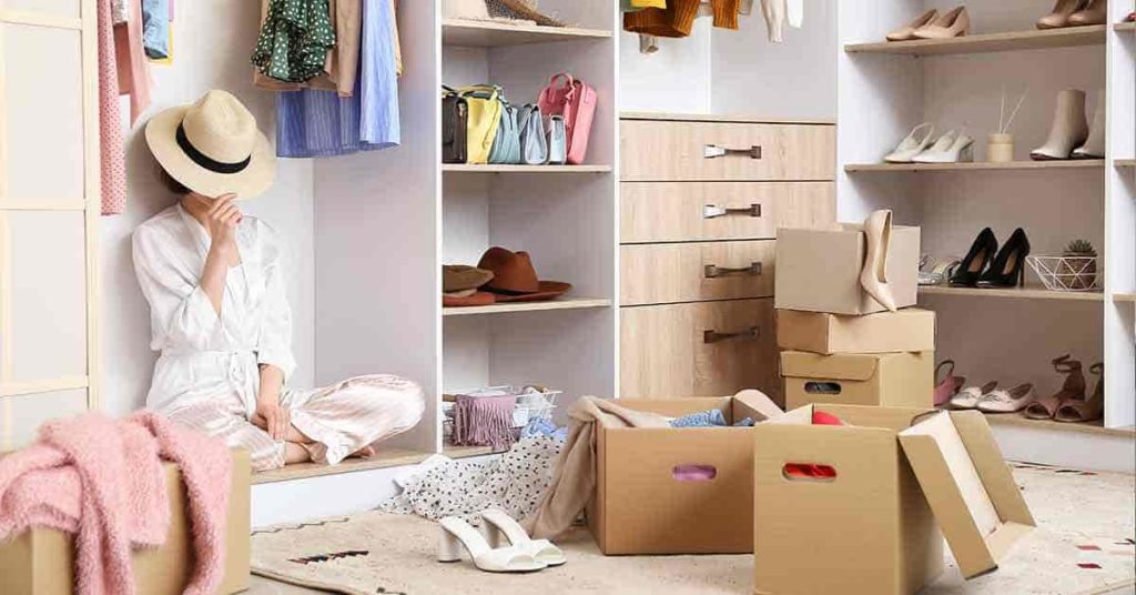 women in hat sitting overwhelmed while Decluttering Wardrobes
